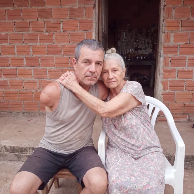 Marcelo e a mãe abraçados em frente de casa
